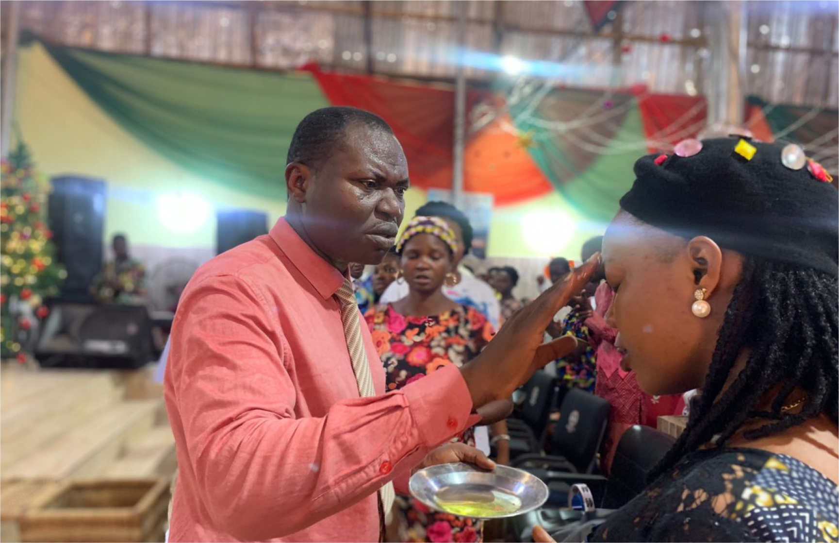 Pastor Femi anointing a member